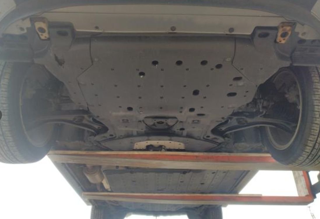 Underbody of the Honda Fit Hybrid on a lift