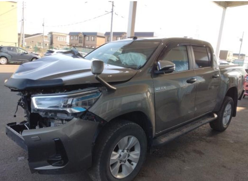 Bronze Toyota Hilux double cab with heavy front-left damage and deployed airbags