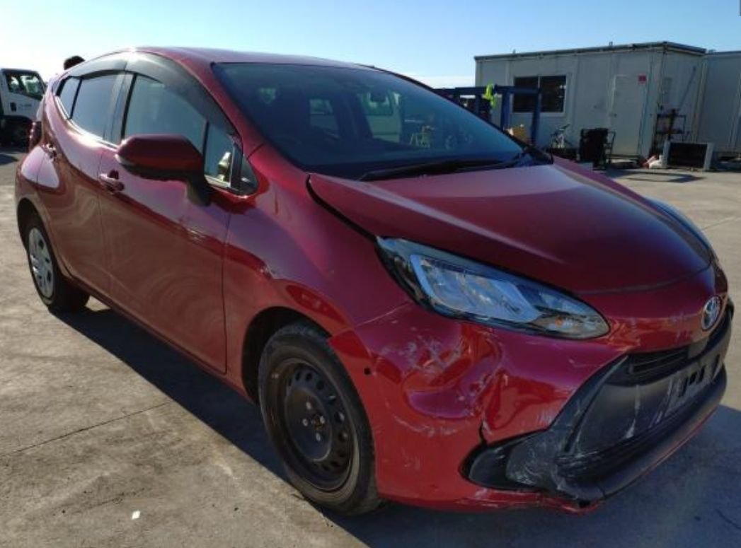 Red Toyota Aqua seen from the front right, showing damage to the front bumper and right front corner