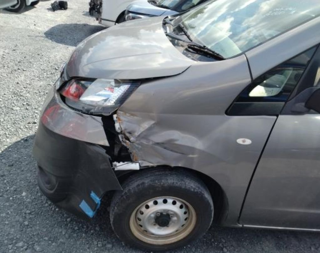 Close-up of the crushed left front fender and bumper