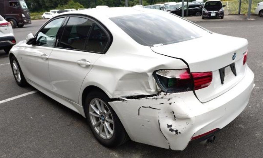 Rear left showing the dented rear quarter and torn bumper