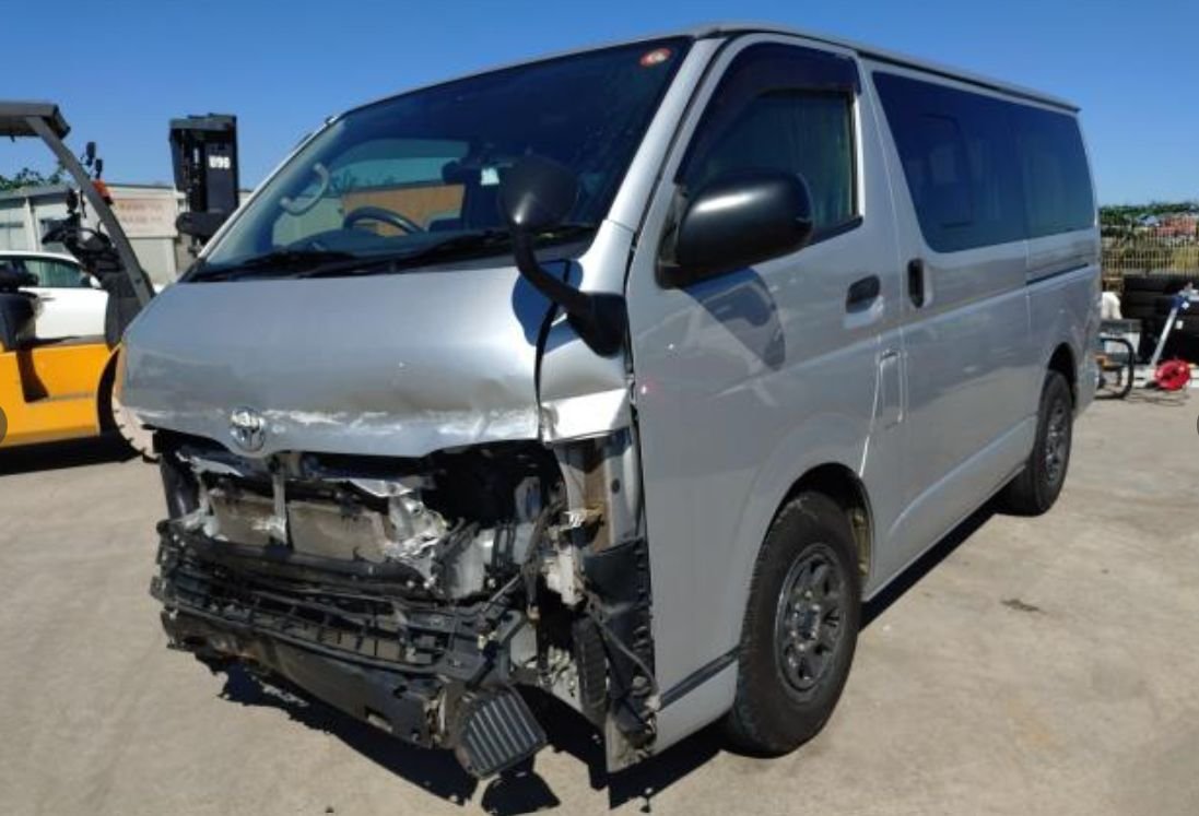 Silver Toyota Hiace van with heavy front-end collision damage