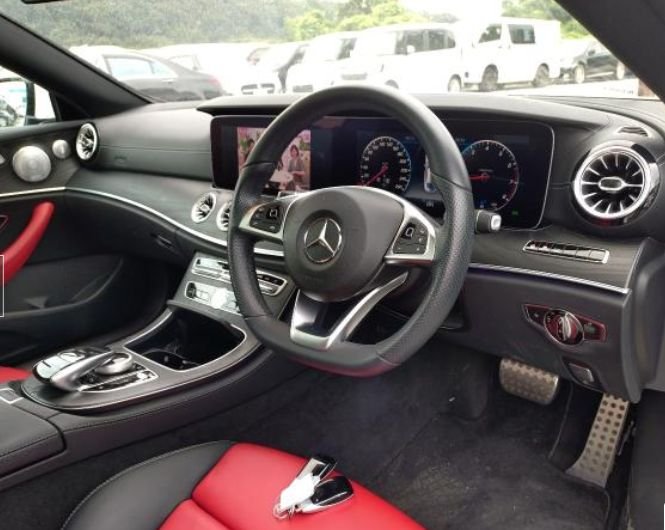 Right-hand-drive dashboard with dual screens and AMG-style steering wheel