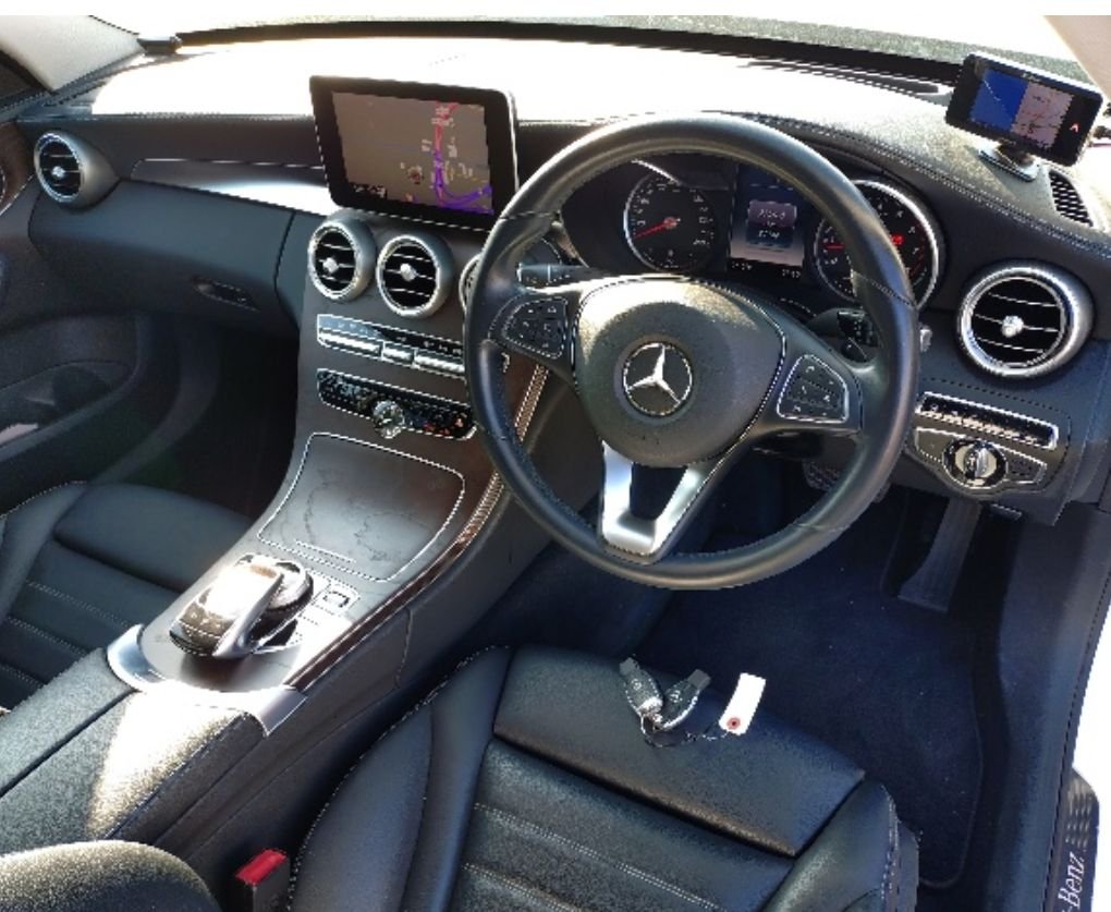 Right-hand-drive interior with black leather seats and navigation