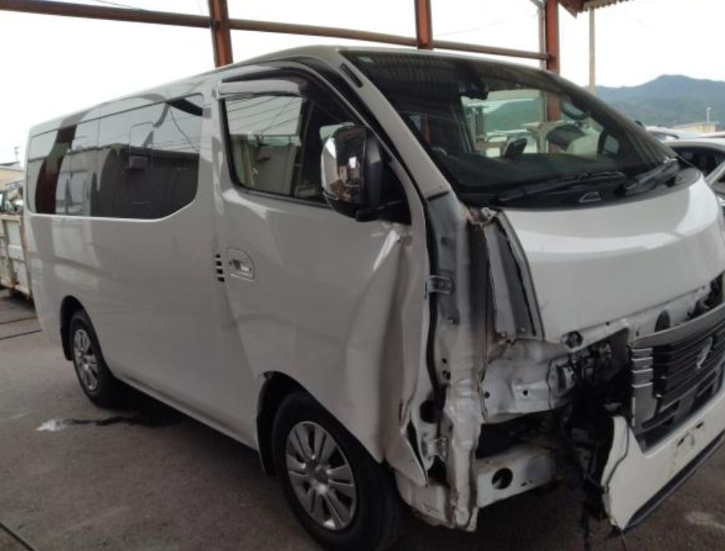White Nissan Caravan van with heavy front-end collision damage