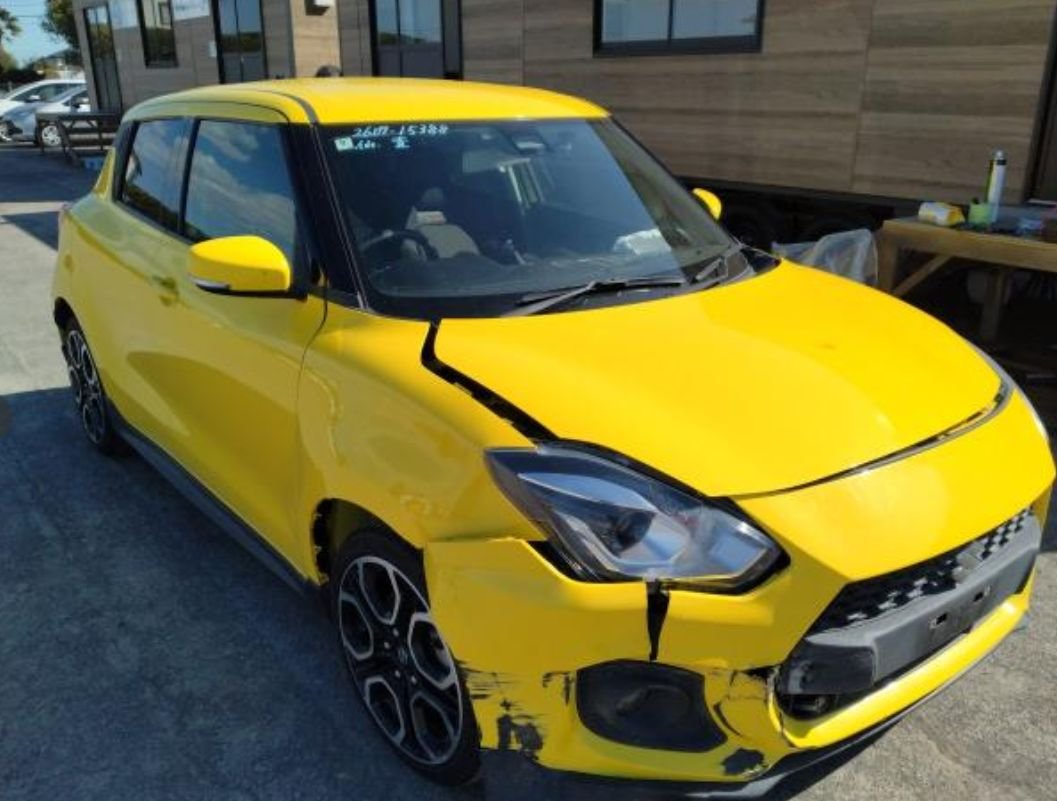 Yellow Suzuki Swift Sport seen from the front right with front-right damage
