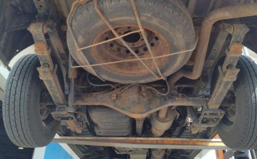 Underbody with surface rust on the rear axle and spare wheel