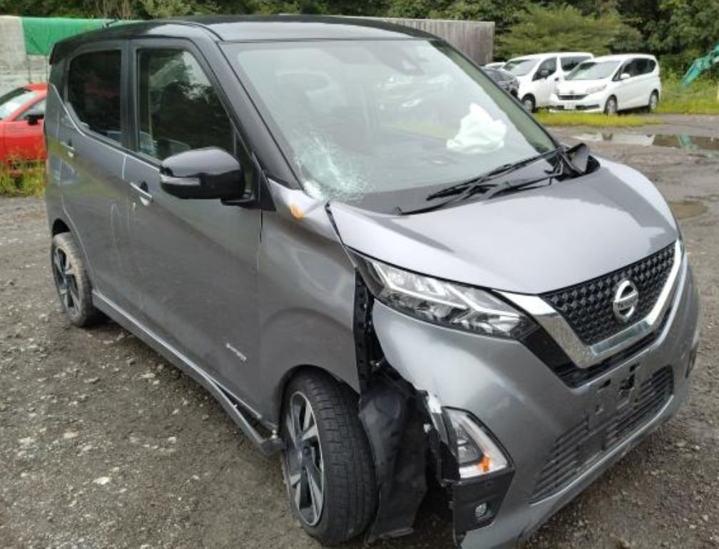 Grey Nissan Dayz Highway Star with heavy front-right damage and a cracked windscreen